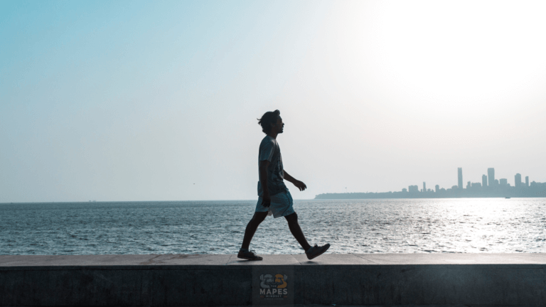 person walking along the water