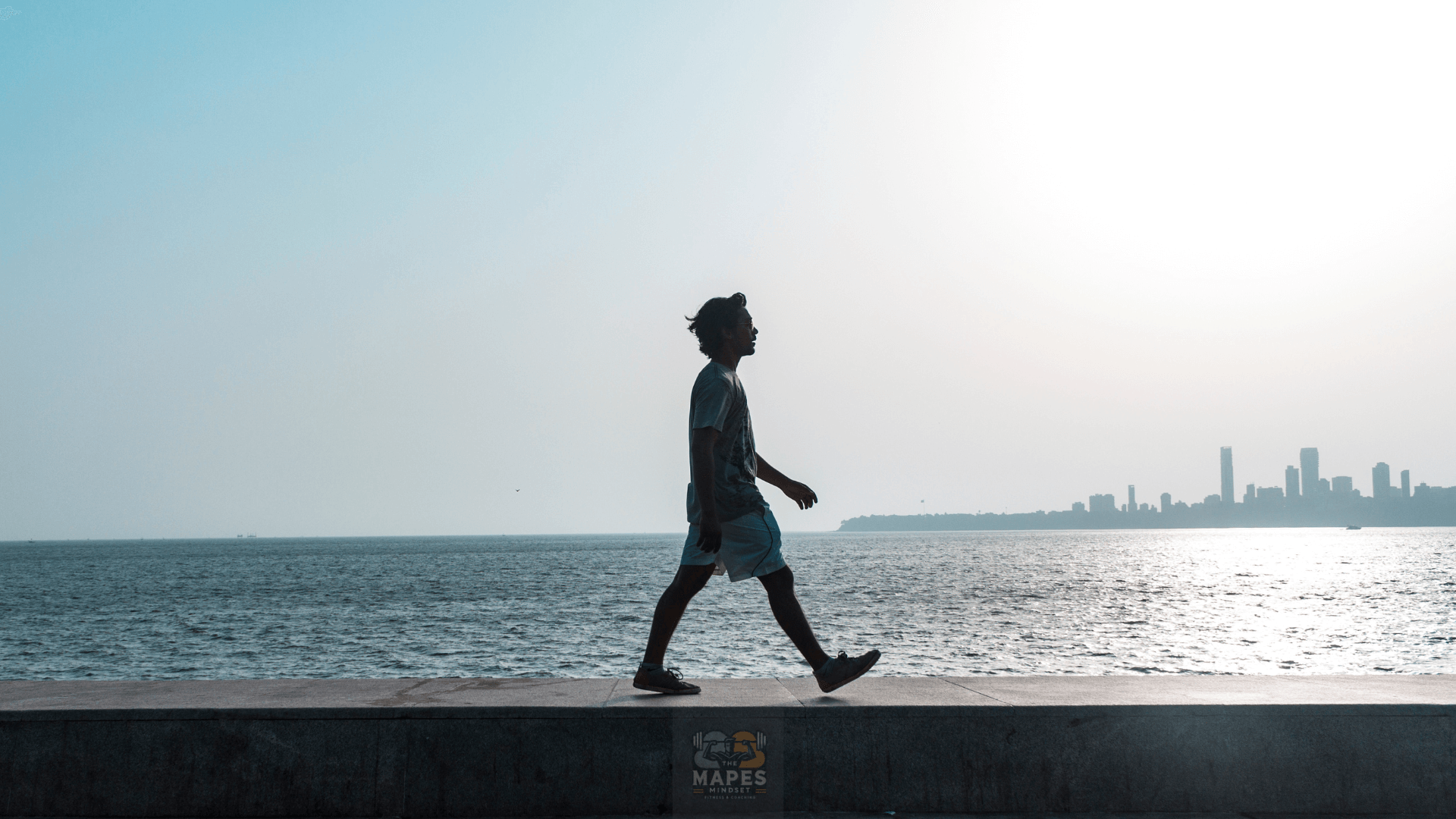 person walking along the water
